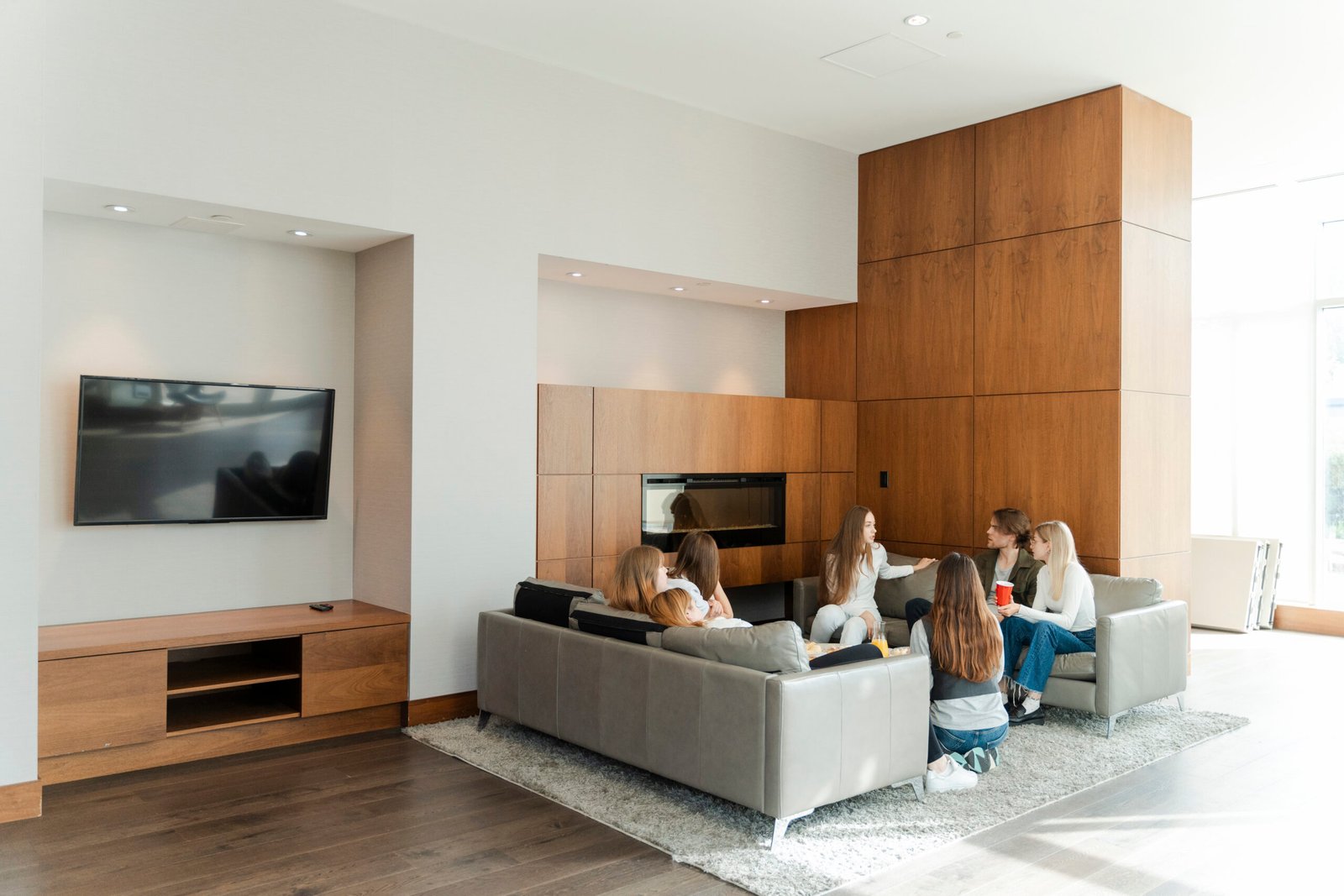 Group of young colleagues sitting at modern home, eating tasty food and talking with each other. People lifestyle concept